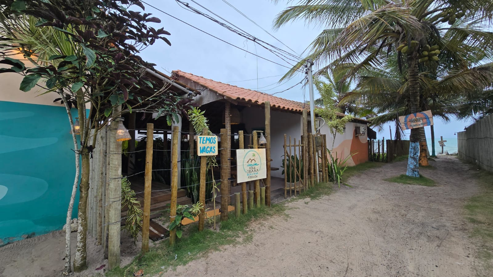 Fachada da Vila Ohana Beira Mar com placa da pousada