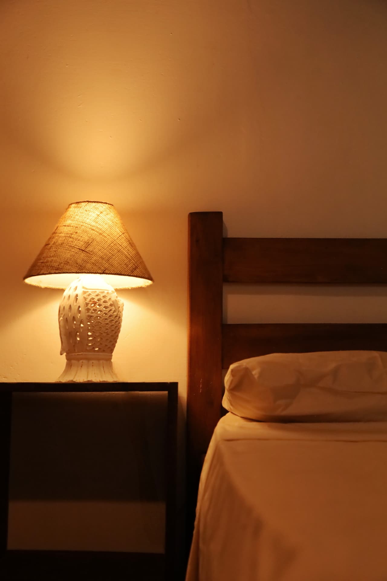 Detalhe do abajur artesanal ao lado da cama